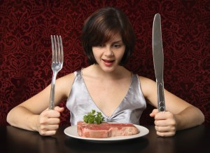 Девушка ест мясо